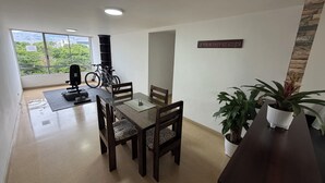 Zona pranzo con tavolo, sedie e vista sulla città.