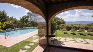 Zona de piscina con vistas a un paisaje urbano a través de un ventanal arqueado.