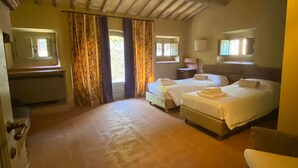Una habitación con dos camas, una mesita y una silla.
