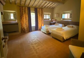 A room with two beds, a small table, and a chair. - Villa Nocciola: a peaceful corner in Tuscany (Arezzo)