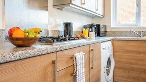 Una cocina moderna con encimeras de granito, electrodomésticos de acero inoxidable y armarios de madera.