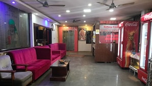 A hotel lobby with seating, a Coca-Cola vending machine, and a reception area. - Aryan (Bhubaneshwar)