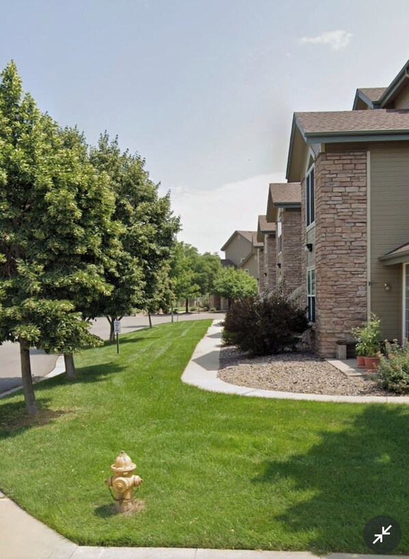 A row of townhouses with stone facades, a well-maintained lawn, and a fire hydrant. - Townhouse just outside of Denver (Littleton)