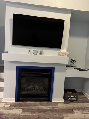 A modern living room with a flat-screen TV mounted above a fireplace. - Townhouse just outside of Denver (Littleton)