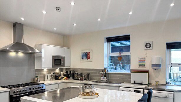 A modern kitchen with a central island, stainless steel appliances, and a window with a view. - 5 bedroom accommodation in Baildon (Baildon)