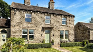 A stone house with a green door, multiple windows, and a chimney. - 5 bedroom accommodation in Baildon (Baildon)