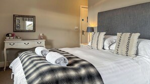 A hotel room with a bed, a dresser, a mirror, and a nightstand. - 5 bedroom accommodation in Baildon (Baildon)