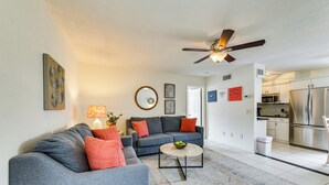 A modern living room with a grey sofa, a coffee table, and a ceiling fan.