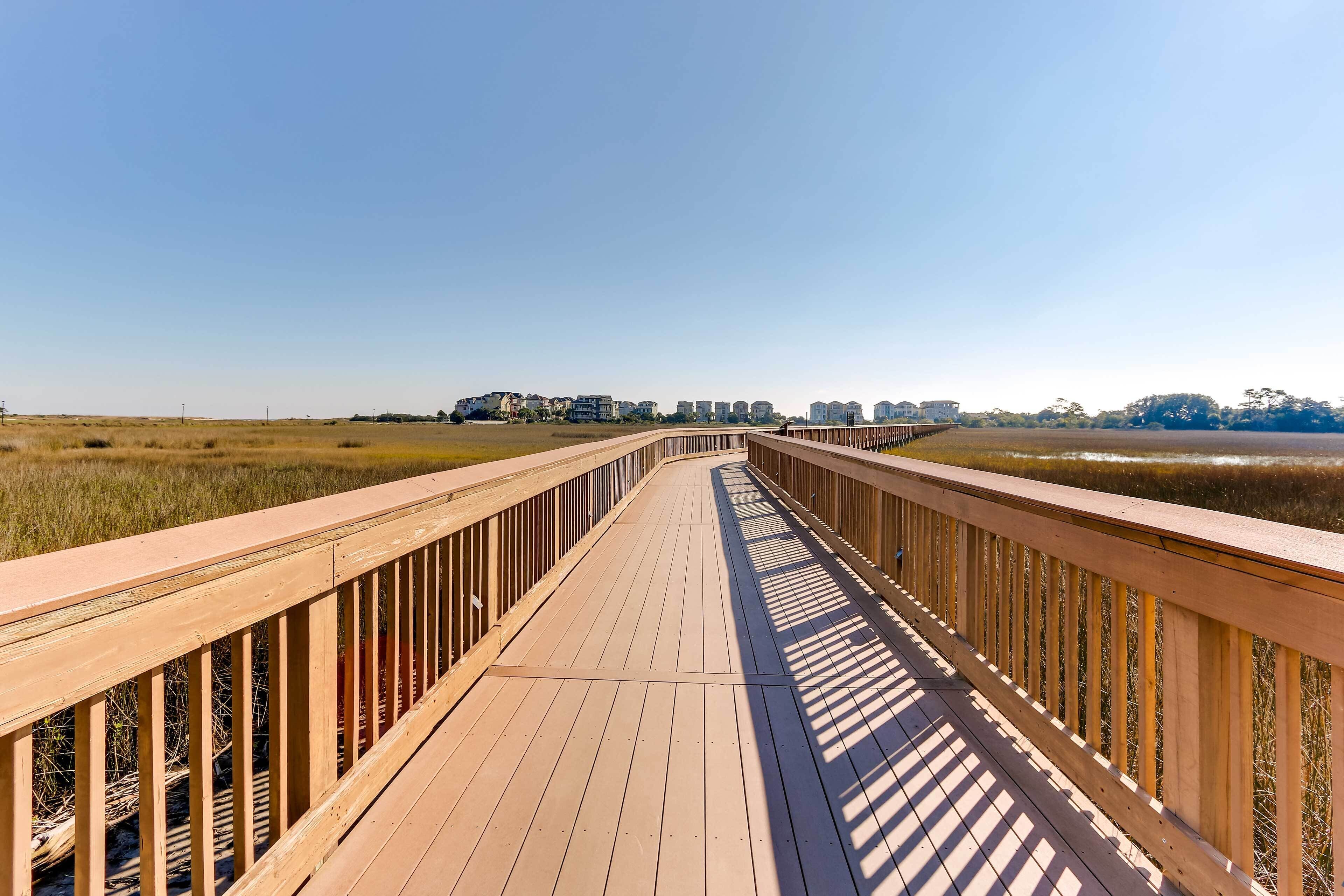 A wooden boardwalk leading to buildings in the distance.