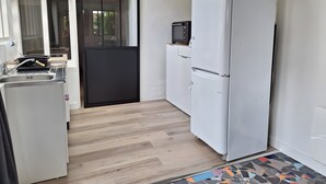 A compact kitchen with a refrigerator, microwave, and sink. - Accommodation in the Heart of the Nantes Vineyard - Near Clisson (Mouzillon)