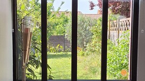 A room with a window, a radiator, a table with a box and papers, and a couch. - Accommodation in the Heart of the Nantes Vineyard - Near Clisson (Mouzillon)