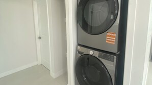 A laundry room with two stacked front-loading washing machines. - Brand-New Modern 2BR /2BA Private Home – Near Little Saigon, K-Town & Disneyland (Santa Ana)
