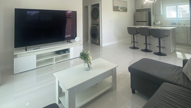 A modern living room with a flat-screen TV, a coffee table, and a sofa. - Brand-New Modern 2BR /2BA Private Home – Near Little Saigon, K-Town & Disneyland (Santa Ana)