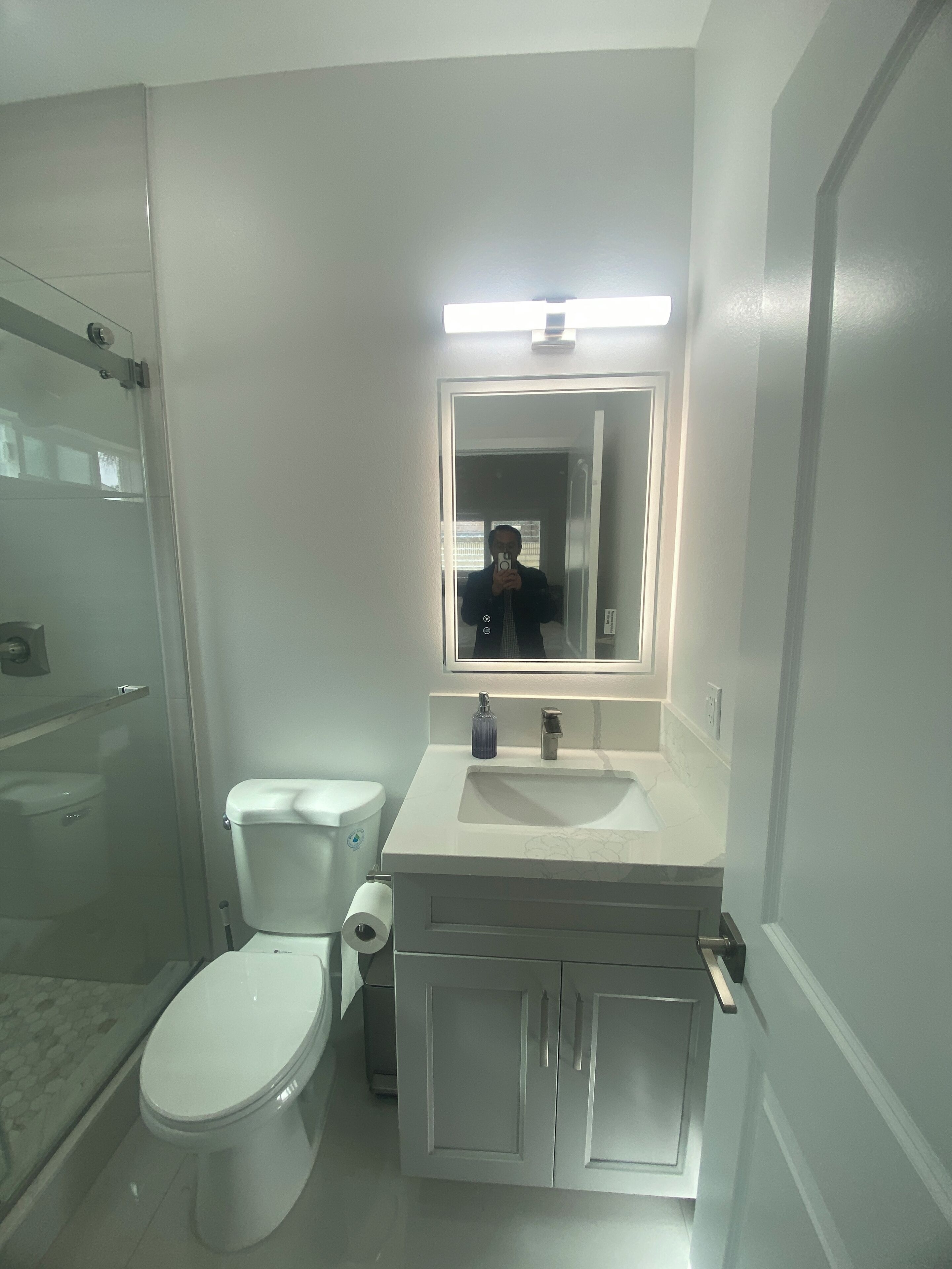 Une salle de bain avec des toilettes, un lavabo et un miroir.