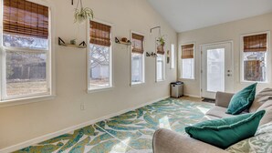 A spacious living room with large windows, a patterned floor, and a sofa with cushions. - 4 Mi to Riverwalk & CSU Pueblo! Home w/ Sunroom (Pueblo)