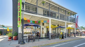 A restaurant with outdoor seating, a balcony, and colorful flags. - Explore Historic Dtwn Punta Gorda! Home w/ Deck (Punta Gorda)