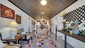 A hallway with a wooden ceiling, a colorful rug, and a Buddha statue on a shelf. - Explore Historic Dtwn Punta Gorda! Home w/ Deck (Punta Gorda)