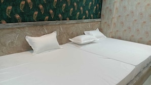 A single-bed room with a marble headboard, white bedding, and a patterned wallpaper on the walls. - Hotel Tulsi Palace (Jaipur)