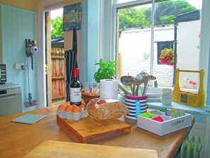 A kitchen counter with a bottle of wine, eggs, a basket of bread, and a box of Clipper brand paper towels. - 2 bedroom accommodation in TOTLAND BAY (TOTLAND BAY)