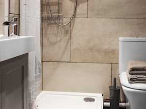 A bathroom with a shower, toilet, and sink. - Maids Cottage - UK51204 (Fishguard)