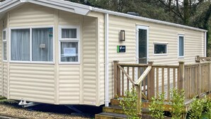 A mobile home with a front porch, a small deck, and a sign indicating 'General Store.' - 2 bedroom accommodation in Wisemans Bridge (Wisemans Bridge)