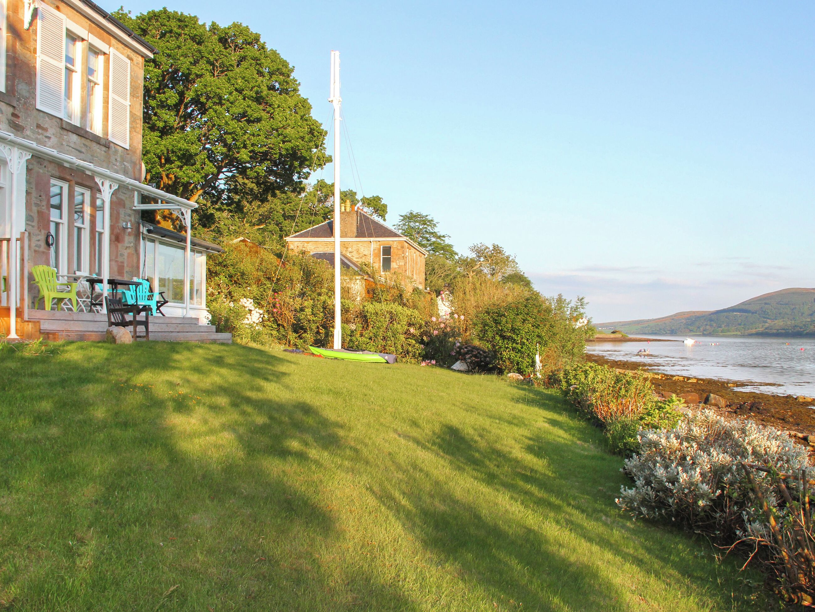 A house with a porch, outdoor furniture, and a view of the sea.