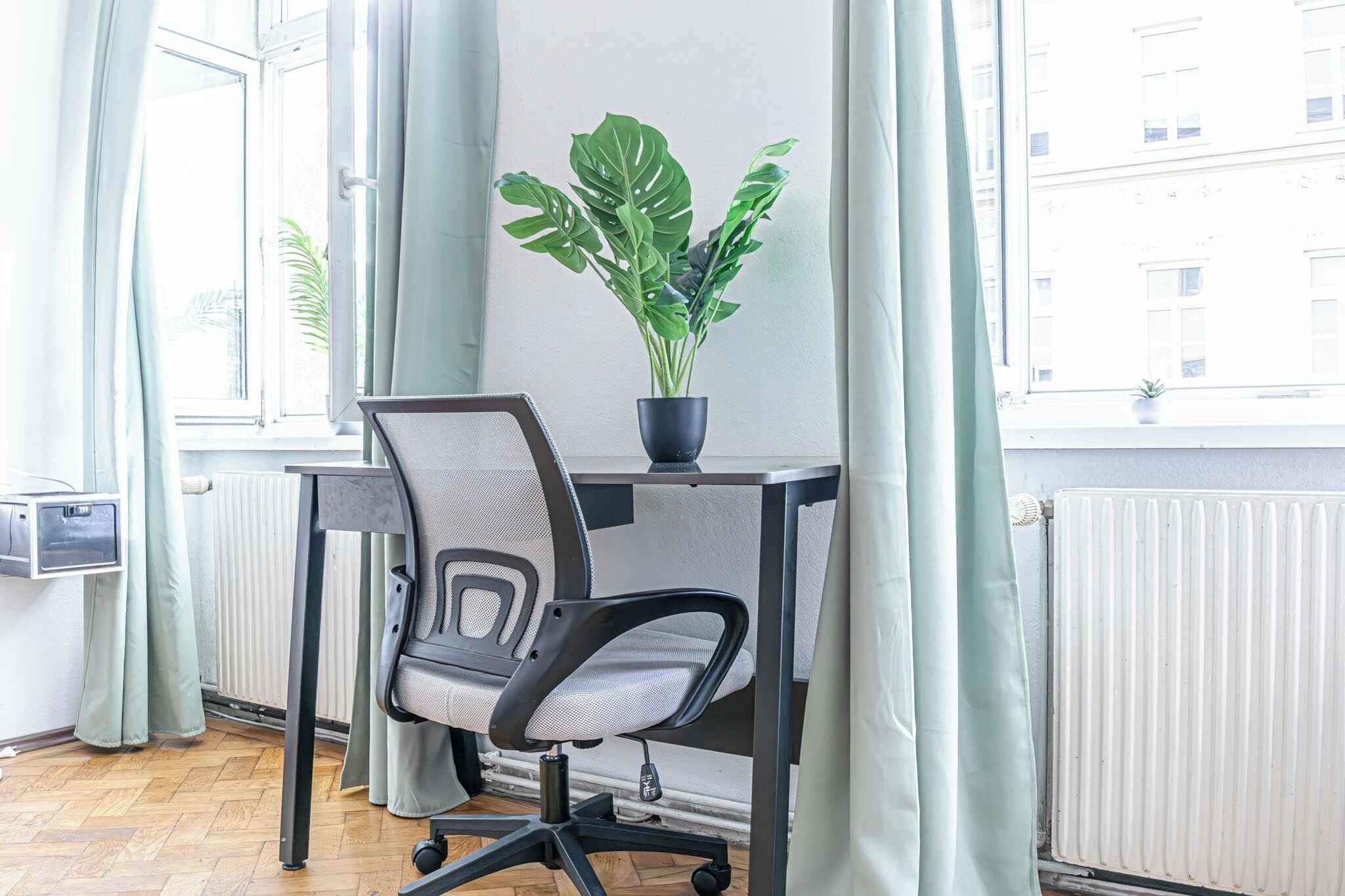 Un espacio de oficina moderno con un escritorio, una silla de oficina y una planta en maceta.