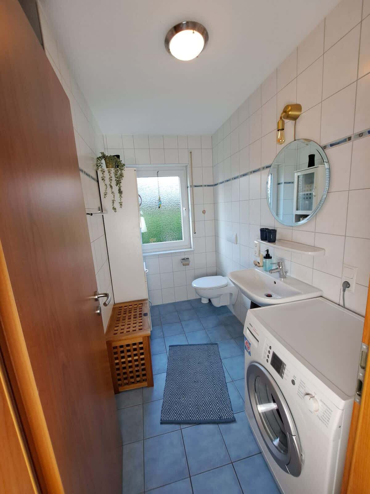 Ein kleines Badezimmer mit Toilette, Waschbecken und Waschmaschine.
