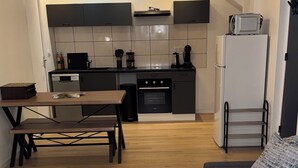 A modern kitchen with dark cabinets, a built-in oven, and a microwave on the counter. - Comfort in Le Mont-Dore - Pets allowed (Mont-Dore)
