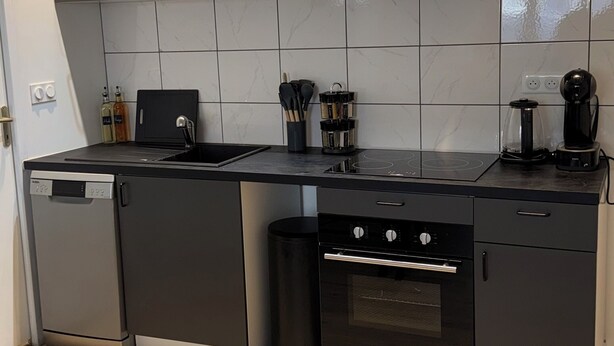 A modern kitchen with integrated appliances, a dishwasher, oven, and a coffee maker. - Comfort in Le Mont-Dore - Pets allowed (Mont-Dore)