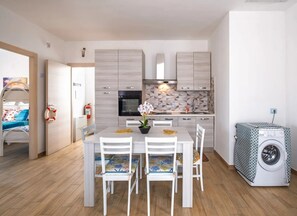Eine moderne Küche mit Essbereich, Holzboden und einer Waschmaschine.