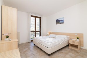 Ein Schlafzimmer mit Bett, Nachttisch und Blick ins Freie.