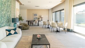 Ein modernes Wohnzimmer mit Sofa, Couchtisch und Essbereich.