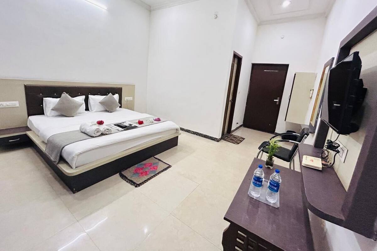 A modern hotel room with a bed, bedside table, and a TV.