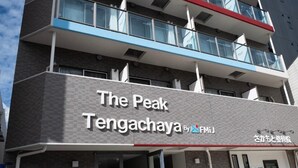 Un immeuble sur lequel on peut lire l’inscription suivante : « The Peak Tengachaya By FMiJ ».
