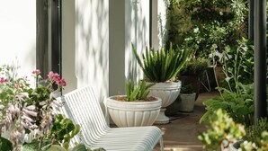 A covered outdoor seating area with white chairs and large planters of various plants. - Months & Seasons - Historic 1860s Estate - Daylesford (Daylesford - Hepburn Springs)