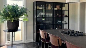 A modern kitchen with a central island, bar stools, a black shelving unit, and a potted plant. - Months & Seasons - Historic 1860s Estate - Daylesford (Daylesford - Hepburn Springs)
