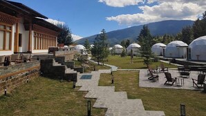 Un complejo turístico con yurtas, senderos de piedra y zonas de estar al aire libre.