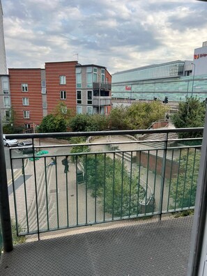 A balcony with a metal railing overlooking a parking area and buildings. - Charming 1-Bedroom Apartment in Central London (London)