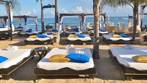 A beachside resort with multiple sunbeds arranged in rows, each with a canopy and pillows. - Crown Penthouse - Luxury & Views   All inclusive (Puerto Plata)