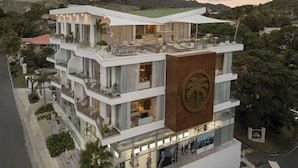 A multi-story building with a modern design, featuring balconies, large windows, and a prominent logo on the facade. - Crown Penthouse - Luxury & Views   All inclusive (Puerto Plata)
