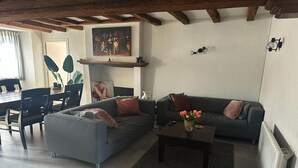 A living room with a sofa, coffee table, and a painting on the wall.