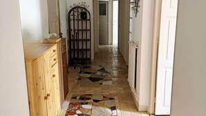 A hallway with a tiled floor, wooden cabinets, and a decorative metal gate. - Nice center 4-room apartment with air conditioning (Nice)