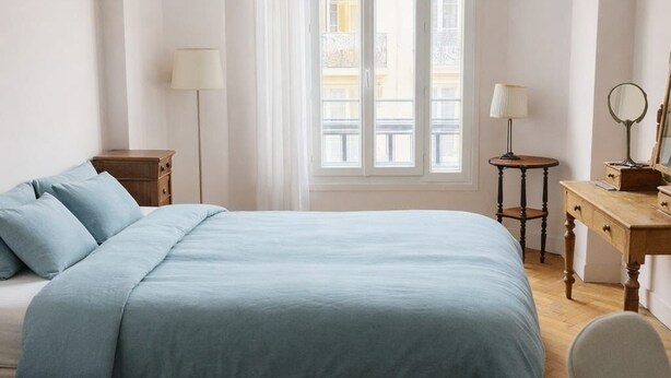 A bedroom with a large bed, a desk with a mirror, and a window with curtains. - Nice center 4-room apartment with air conditioning (Nice)