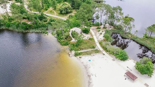 An aerial view of a beach with a small building, a path, and dense greenery. - Nice home in Noaillan (Noaillan)