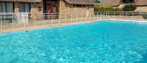 A swimming pool with a stone building in the background.