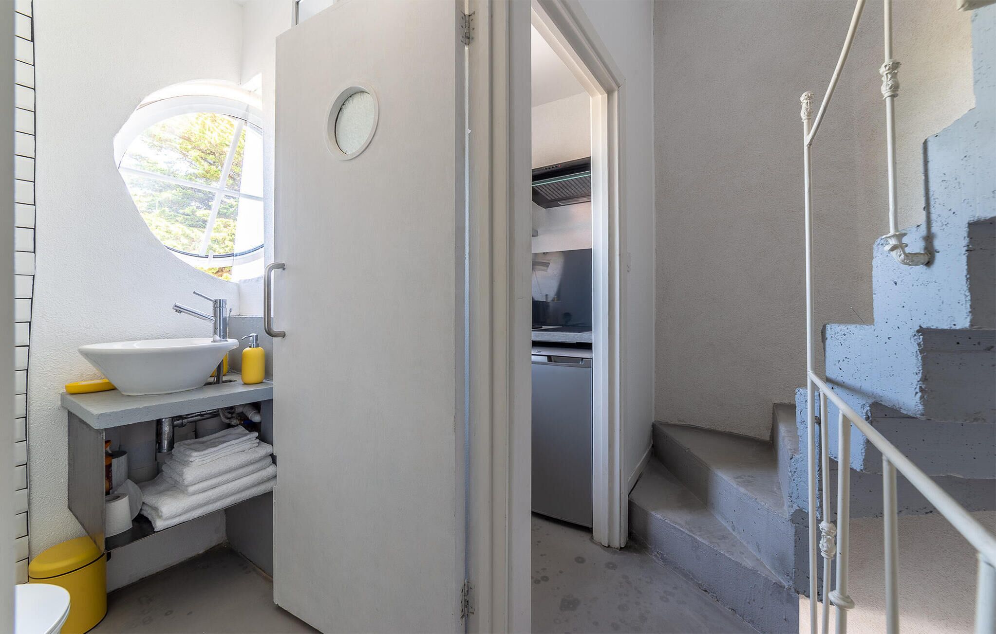 Un baño con lavamanos, inodoro y ventana.