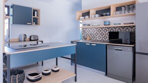 A modern kitchen with a blue countertop, stainless steel appliances, and wooden shelves. - 2stay apartment Calla Bloubergstrand  (Cape Town)