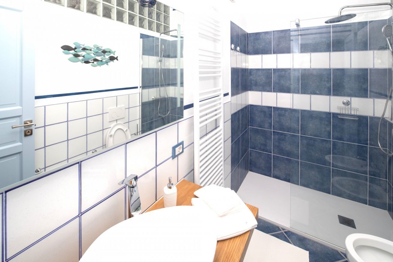Een douche, een bidet, handdoeken, toiletpapier