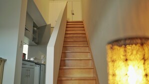 Un escalier mène au deuxième étage, où se trouve un coin cuisine sur la gauche.